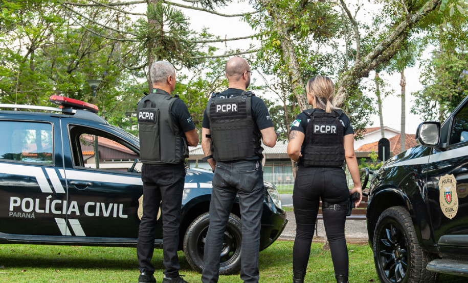 Três policiais civis entre viaturas