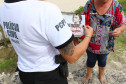 Policial civil entregando panfleto da campanha contra a dengue para veranista