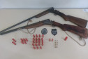 Duas armas e diversas munições sobre uma mesa