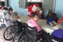 Papai Noel cumprimentando idosos do lar na mesa de refeição 