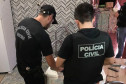 Policiais civis recolhendo notebook em residência