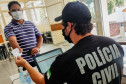 Policial civil consultando carteira de vacinação