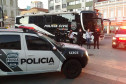 Policiais civis posando para foto entre viaturas e ônibus da PCPR