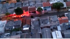 Cena aérea da mostrando casas e viaturas da polícia civil na rua