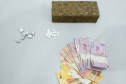 Droga e cédulas de dinheiro sobre uma mesa