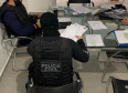 Policiais civis verificando documentos 