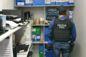 Policial civil observa estante com arquivos