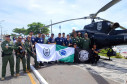Integrantes do GOA segurando bandeiras, junto a helicóptero