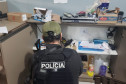 Policial civil investigando prateleiras com diversos objetos