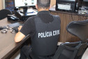 Policial civil de costas, ao computador