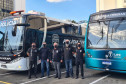 Policiais civis posando para foto entre ônibus da PCPR e TJ