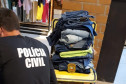 Policial civil, de costas, analisando mercadoria da loja