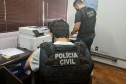 Policiais civis analisando documentos 