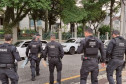 Seis policiais civis de costas, atravessando a rua