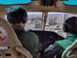 Pilotos em helicóptero sobrevoando a cidade