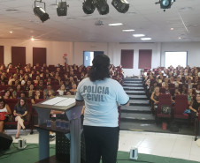 Policial civil ministrando palestra em auditório para educares da rede municipal de Matinhos