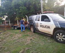 Policial com viatura da PCPR aparecem na foto cumprindo mandado de busca e apreensão em Foz do Iguaçu