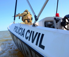 Policial civil empunhando fuzis em barco da corporação