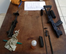 Armas desmontadas e material de limpeza sobre uma mesa