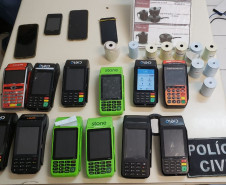 Diversas maquinas de cartão e celulares sobre uma mesa