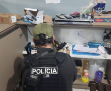 Policial civil investigando prateleiras com diversos objetos