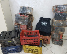 Diversas caixas com a droga e colete da polícia civil