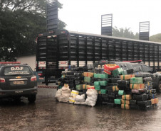 Pacotes da droga empilhados ao lado de caminhão