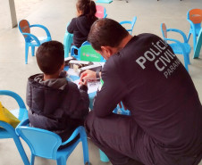 Policial civil acompanha criança em atividade lúdica