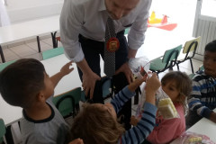 Policial civil entregando doces para crianças na sala de aula