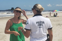 Policial civil orientando uma veranista no litoral