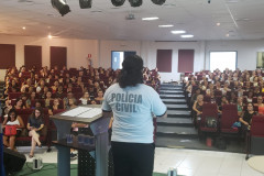 Policial civil ministrando palestra em auditório para educares da rede municipal de Matinhos