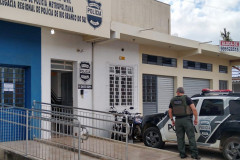 Fachada da Policia Civil de Rio Branco, com policial em pé, de costas, e viatura ao lado