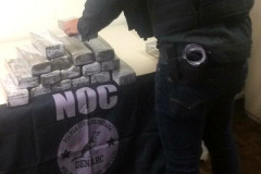 Policial civil empilhando tabletes de droga apreendida