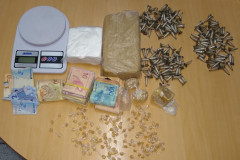 Balança, cédulas de dinheiro e drogas sobre uma mesa