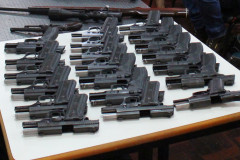 Diversas armas agrupadas sobre uma mesa