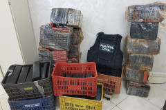 Diversas caixas com a droga e colete da polícia civil