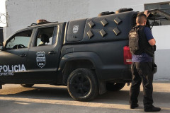 Policial civil abrindo tampa do porta-malas de viatura