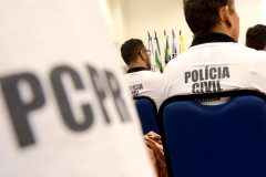 Policiais civis de costas, sentados. Em primeiro plano, nome PCPR.