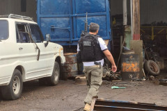 Policial civil armado com fuzil e pistola, entrando em estabelecimento