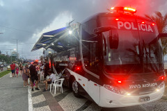 Onibus com viatura móvel estacionado e policiais civis atendendo veranistas