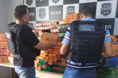 Policiais civis empilhando tabletes de droga apreendida