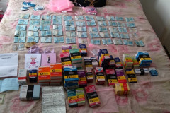 Dezenas de caixas de remédio e cédulas de dinheiro sobre uma cama