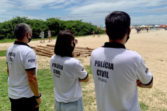 Três policiais civis observando movimento no litoral