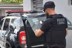 Policial civil fechando tampa do porta-malas de viatura