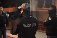 Policial civil de costas, conversando com outros policiais
