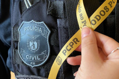 Policial civil com colete mostrando e fita