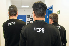 Três policiais no interior de delegacia