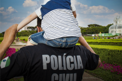 Policial civil com criança sobre os ombros