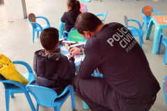 Policial civil acompanha criança em atividade lúdica