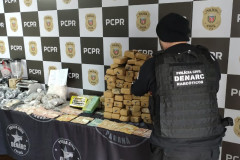 Policial civil organizando material apreendido sobre uma mesa